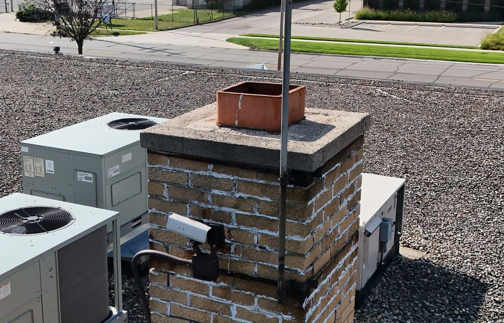 Commercial brick chimney with eroded, washed out mortar joints