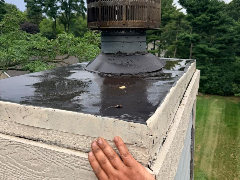 A hand resting on the edge of a freshly coated chase cover