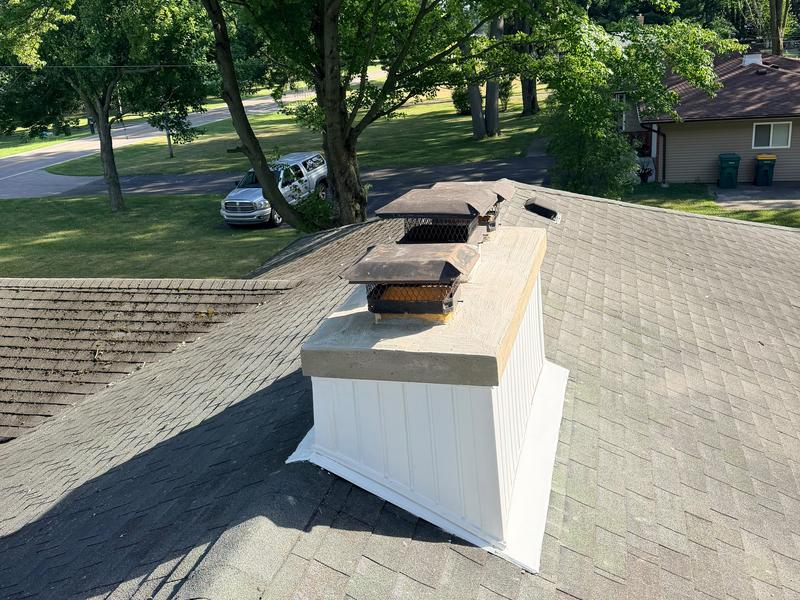 Roof view of a finished white chase with three capped flues